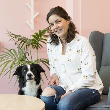 Una chica con su perro border collie sentada en un sillón. Está en un coworking dog friendly.